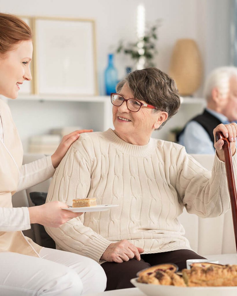 nurse-serving-cake-for-pensioner-PVD6QNS.jpg